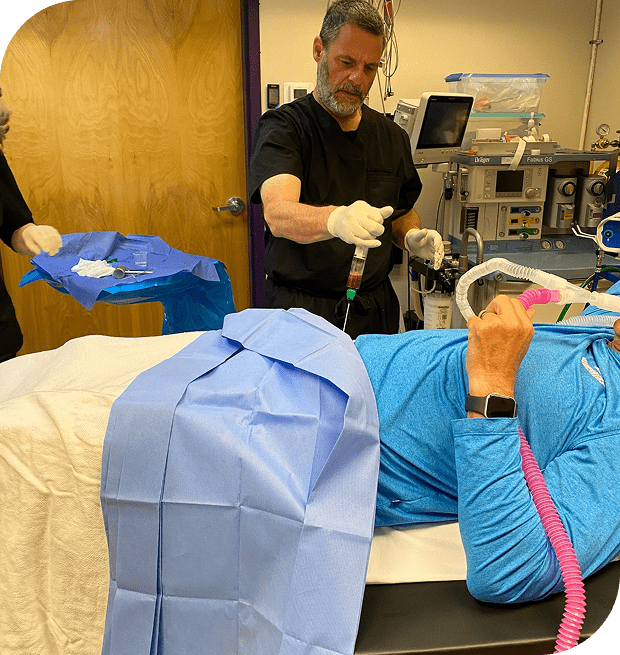 Medical procedure with doctors and patient lying down.
